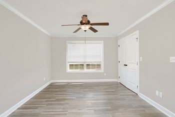 a spacious bedroom with with double window, ceiling fan, and vinyl plank flooring at The Meadows Apartments in Florence, AL